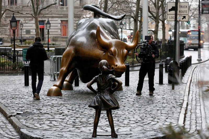 A statue of a defiant girl now confronts the famous “Charging Bull” on Wall St.